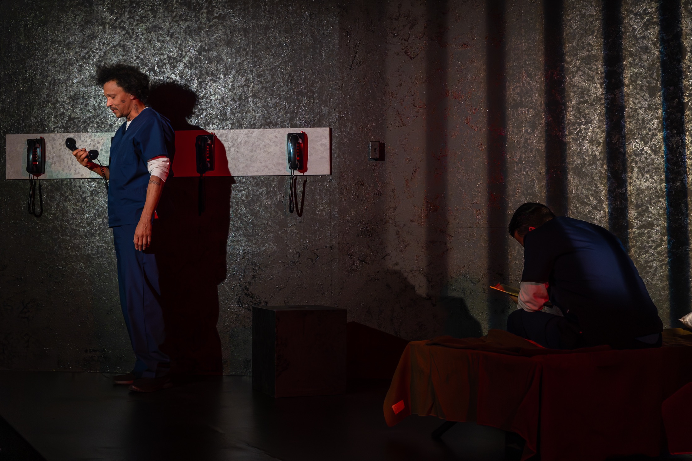 An Inside Out actor using a phone on the prison set