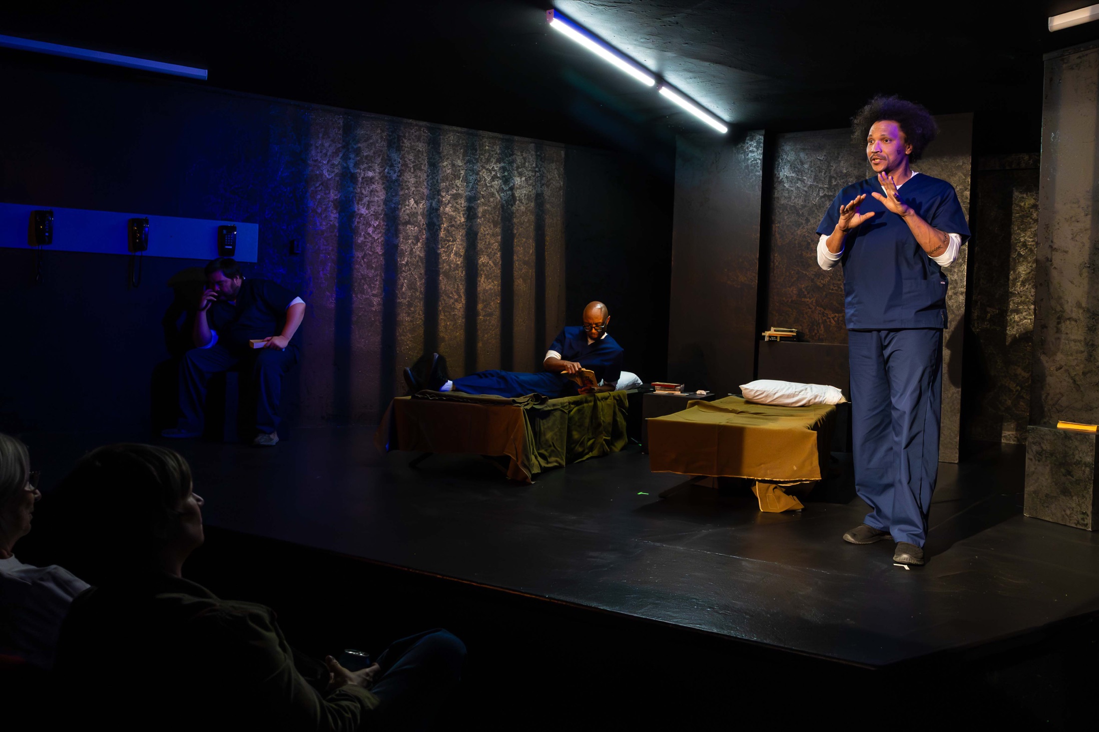 Three performers on the Inside Out stage with audience members visible in the foreground
